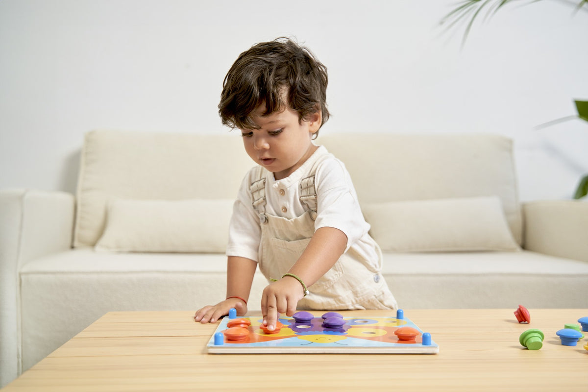 A child matching wooden buttons to the classic colour puzzle