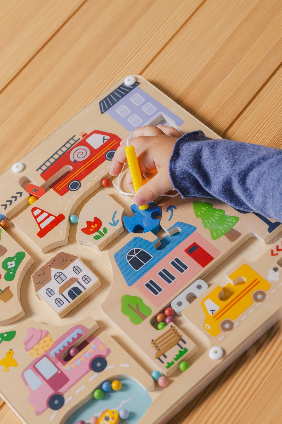 A child guiding colorful beads through the Nene Toys Magnetic City Maze