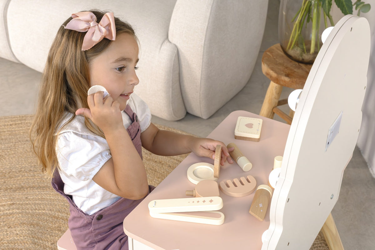 A close-up of a child playing with the wooden beauty accessories at My First Vanity Table